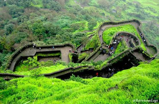 "Best Places to Visit in India – Winding pathway leading to Rajmachi Fort surrounded by lush green hills in Maharashtra."